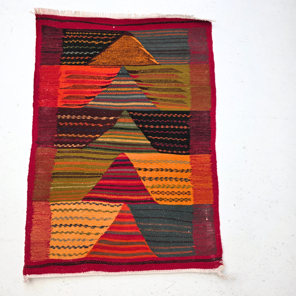 Bohemian Moroccan Azilal rug with bold geometric patterns in red, orange, purple, and multicolor wool, featuring abstract Berber tribal motifs and handwoven texture.