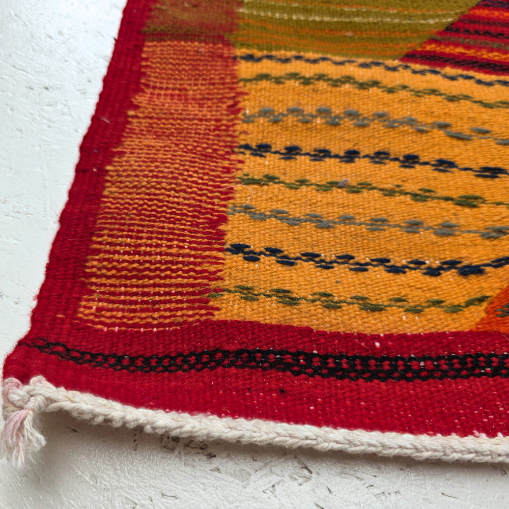 Bohemian Moroccan Azilal rug with bold geometric patterns in red, orange, purple, and multicolor wool, featuring abstract Berber tribal motifs and handwoven texture.