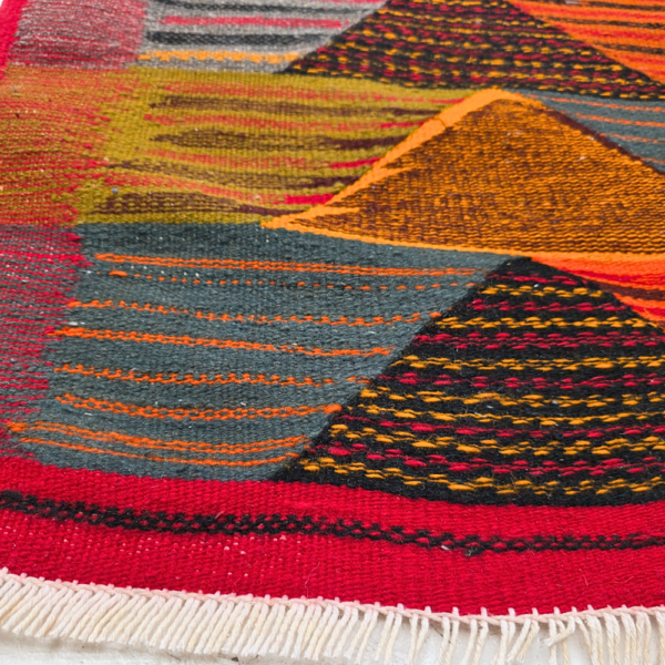 Bohemian Moroccan Azilal rug with bold geometric patterns in red, orange, purple, and multicolor wool, featuring abstract Berber tribal motifs and handwoven texture.