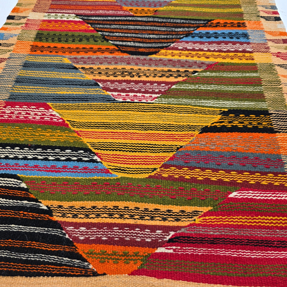 Bohemian Moroccan Azilal rug with bold geometric patterns in red, orange, purple, and multicolor wool, featuring abstract Berber tribal motifs and handwoven texture.