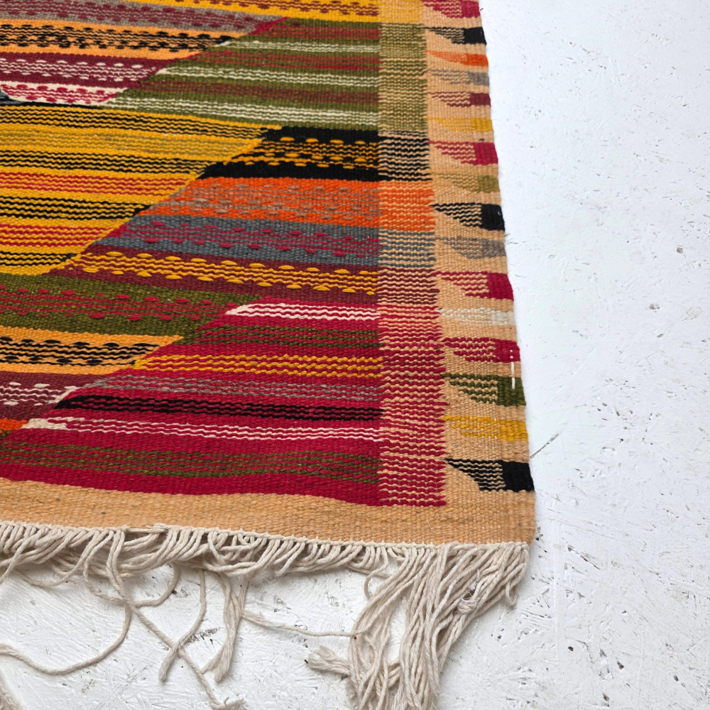 Bohemian Moroccan Azilal rug with bold geometric patterns in red, orange, purple, and multicolor wool, featuring abstract Berber tribal motifs and handwoven texture.