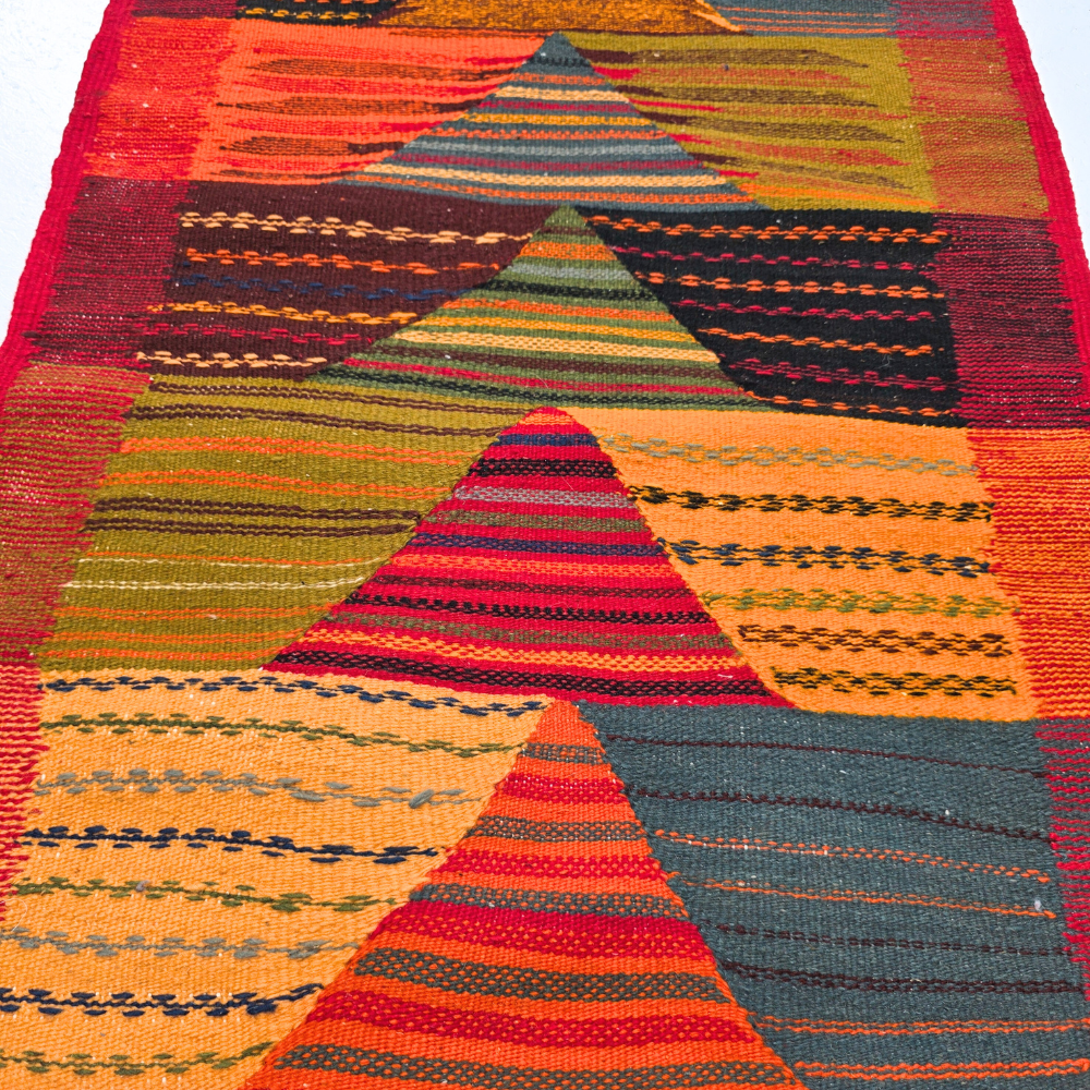 Bohemian Moroccan Azilal rug with bold geometric patterns in red, orange, purple, and multicolor wool, featuring abstract Berber tribal motifs and handwoven texture.