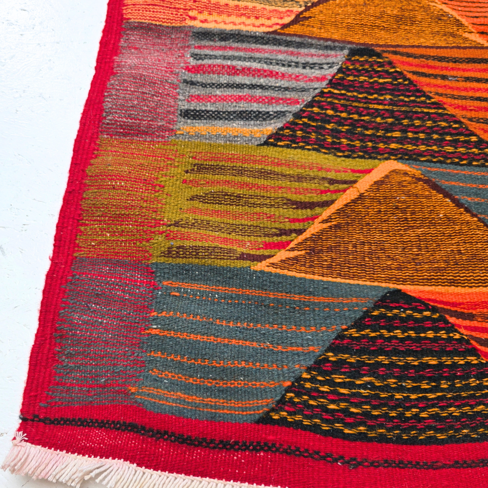 Bohemian Moroccan Azilal rug with bold geometric patterns in red, orange, purple, and multicolor wool, featuring abstract Berber tribal motifs and handwoven texture.
