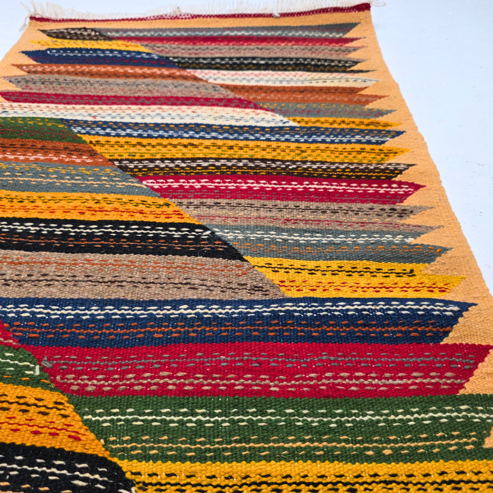 Bohemian Moroccan Azilal rug with bold geometric patterns in red, orange, purple, and multicolor wool, featuring abstract Berber tribal motifs and handwoven texture.