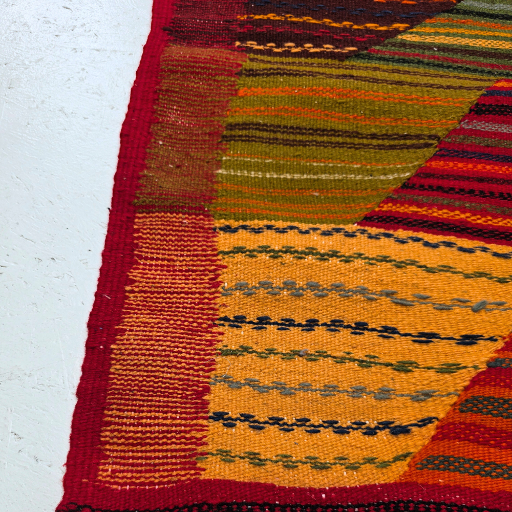 Bohemian Moroccan Azilal rug with bold geometric patterns in red, orange, purple, and multicolor wool, featuring abstract Berber tribal motifs and handwoven texture.