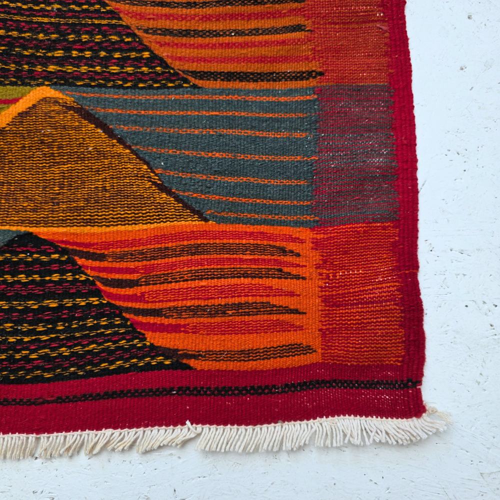 Bohemian Moroccan Azilal rug with bold geometric patterns in red, orange, purple, and multicolor wool, featuring abstract Berber tribal motifs and handwoven texture.