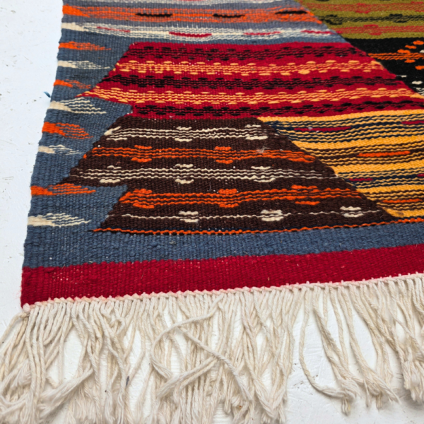 Bohemian Moroccan Azilal rug with bold geometric patterns in red, orange, purple, and multicolor wool, featuring abstract Berber tribal motifs and handwoven texture.