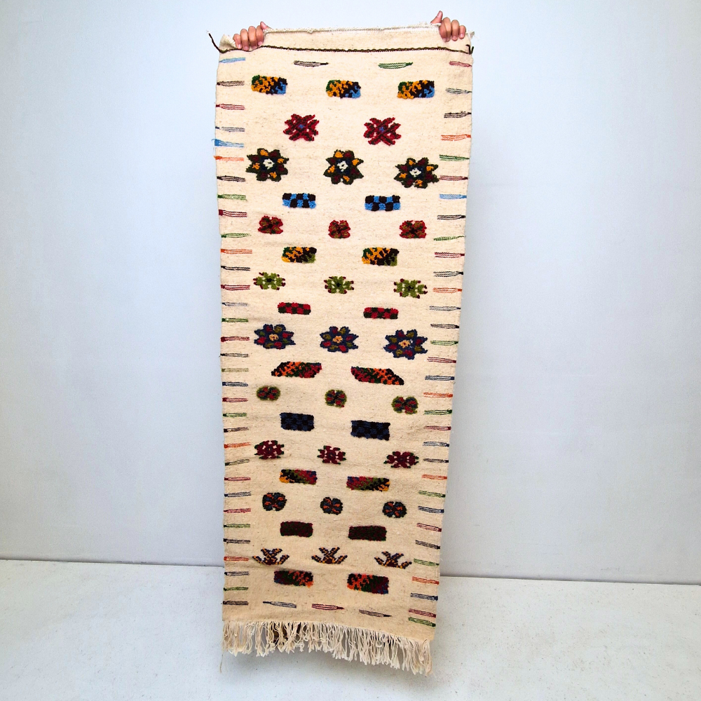 Bohemian Moroccan Azilal rug with bold geometric patterns in red, blue, white and multicolor wool, featuring abstract Berber tribal motifs and handwoven texture.