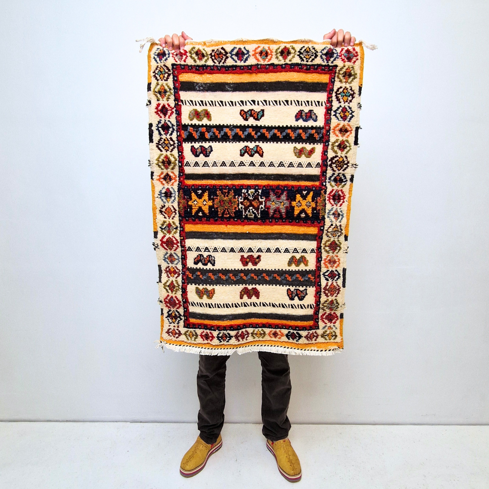 Bohemian Moroccan Azilal rug with bold geometric patterns in red, blue, white and multicolor wool, featuring abstract Berber tribal motifs and handwoven texture.