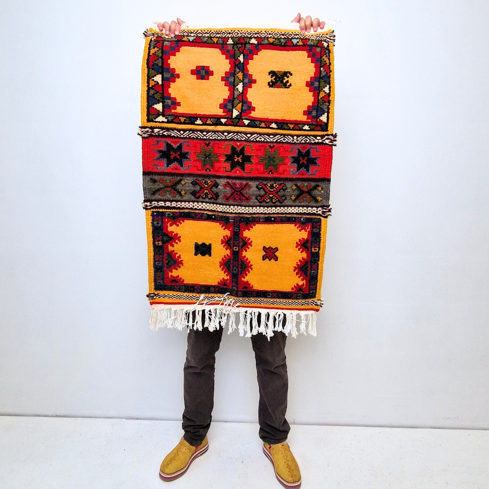 Bohemian Moroccan Azilal rug with bold geometric patterns in red, blue, white and multicolor wool, featuring abstract Berber tribal motifs and handwoven texture.