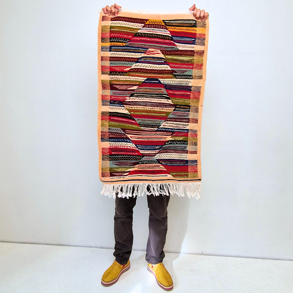 Bohemian Moroccan Azilal rug with bold geometric patterns in red, orange, purple, and multicolor wool, featuring abstract Berber tribal motifs and handwoven texture.