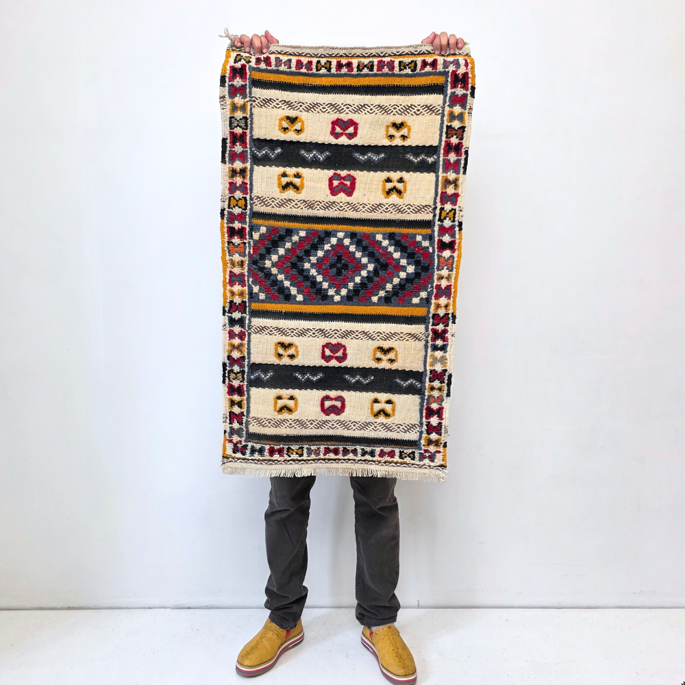 Bohemian Moroccan Azilal rug with bold geometric patterns in red, blue, white and multicolor wool, featuring abstract Berber tribal motifs and handwoven texture.