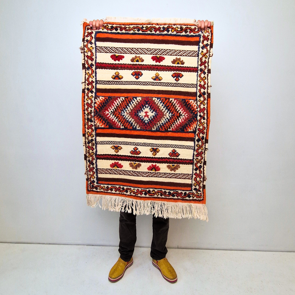 Bohemian Moroccan Azilal rug with bold geometric patterns in red, blue, white and multicolor wool, featuring abstract Berber tribal motifs and handwoven texture.