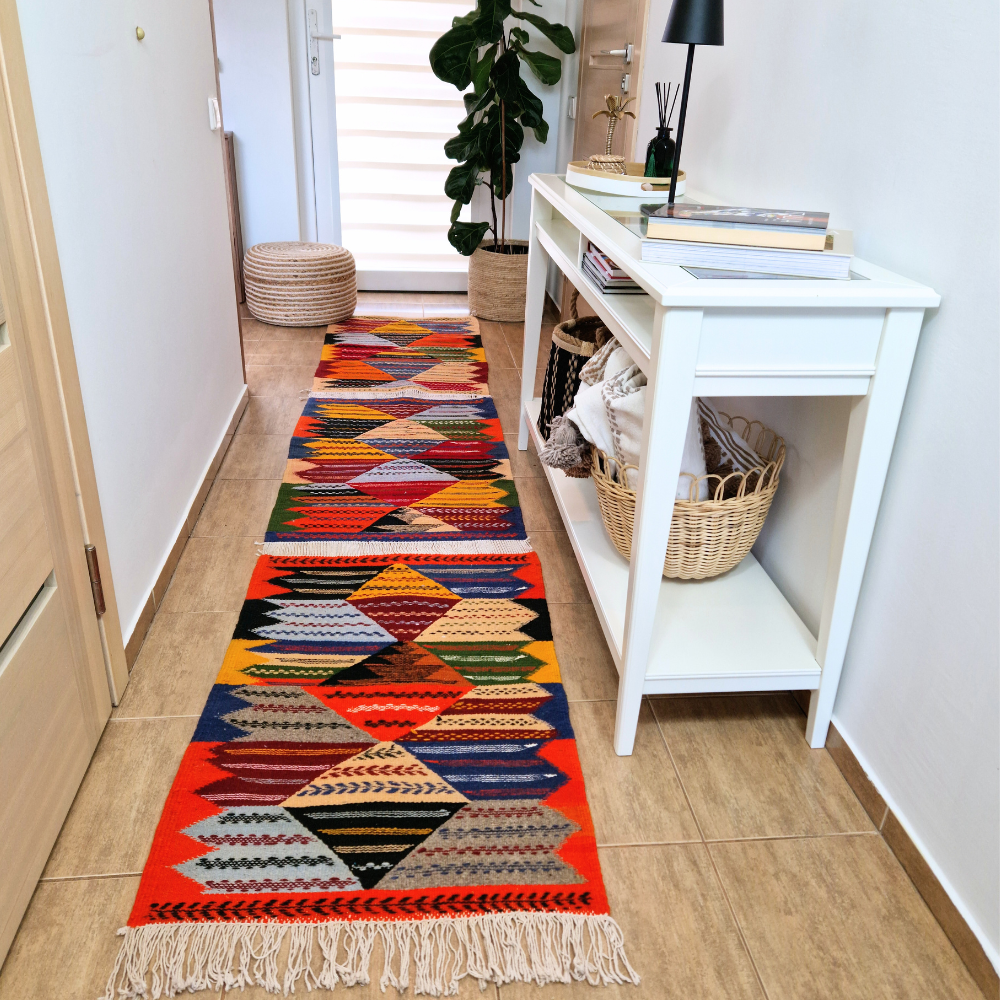 Bohemian Moroccan Azilal rug with bold geometric patterns in red, blue, white and multicolor wool, featuring abstract Berber tribal motifs and handwoven texture.