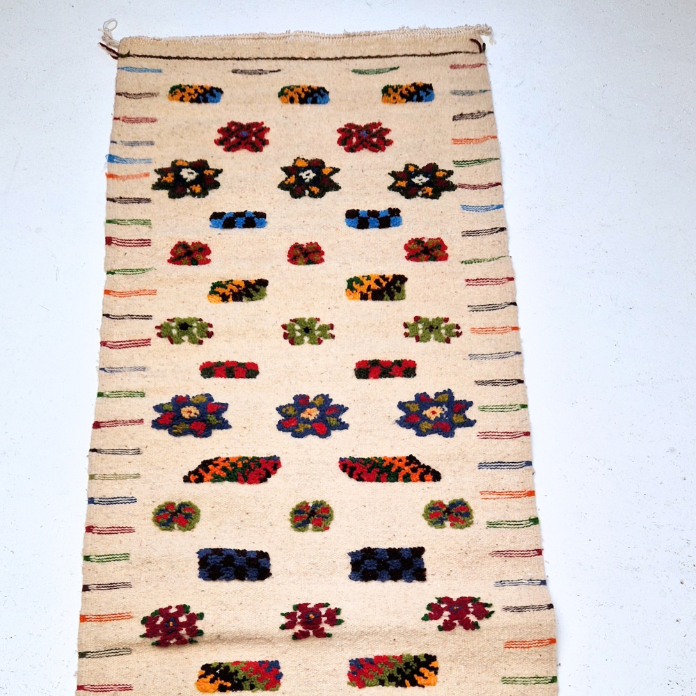 Bohemian Moroccan Azilal rug with bold geometric patterns in red, blue, white and multicolor wool, featuring abstract Berber tribal motifs and handwoven texture.