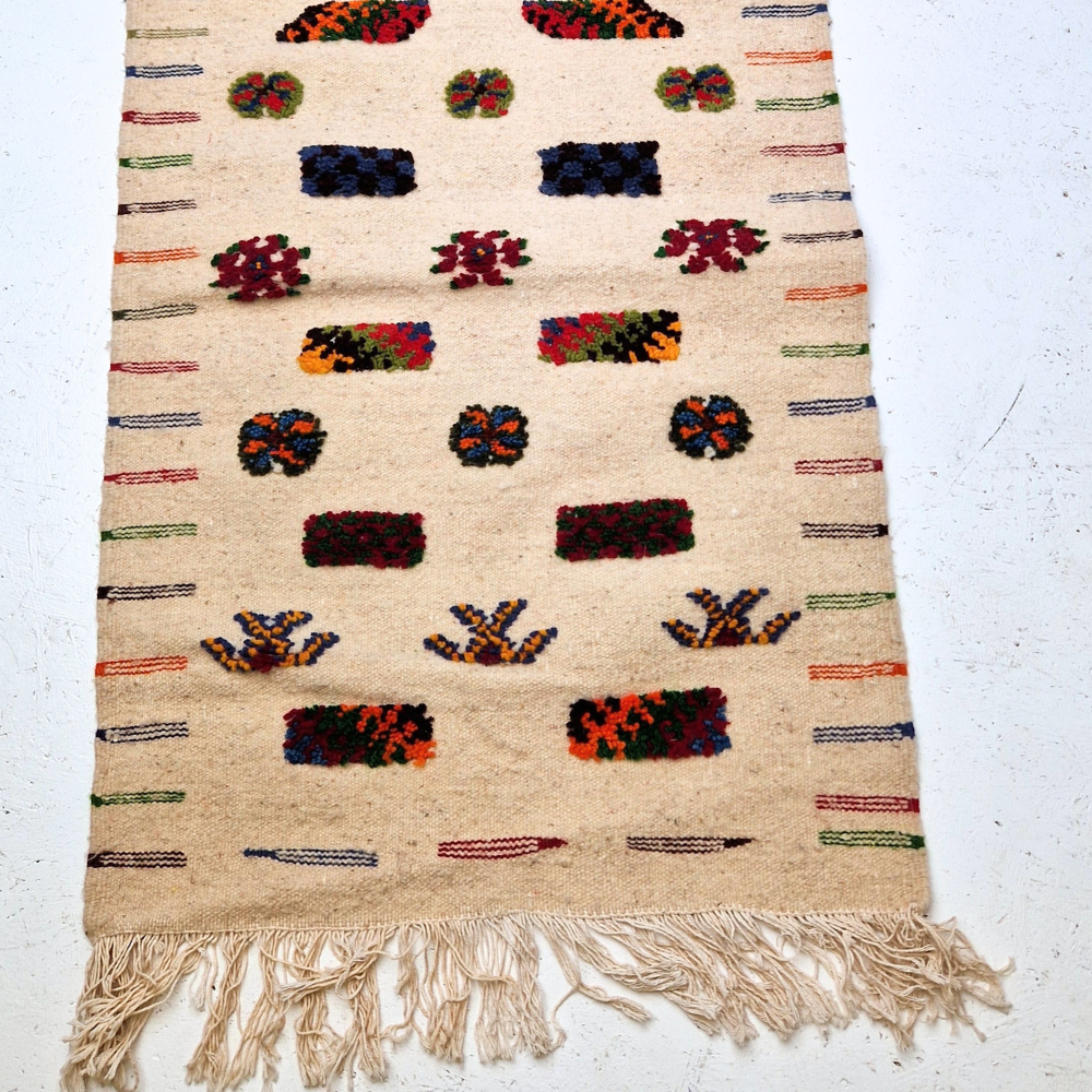 Bohemian Moroccan Azilal rug with bold geometric patterns in red, blue, white and multicolor wool, featuring abstract Berber tribal motifs and handwoven texture.