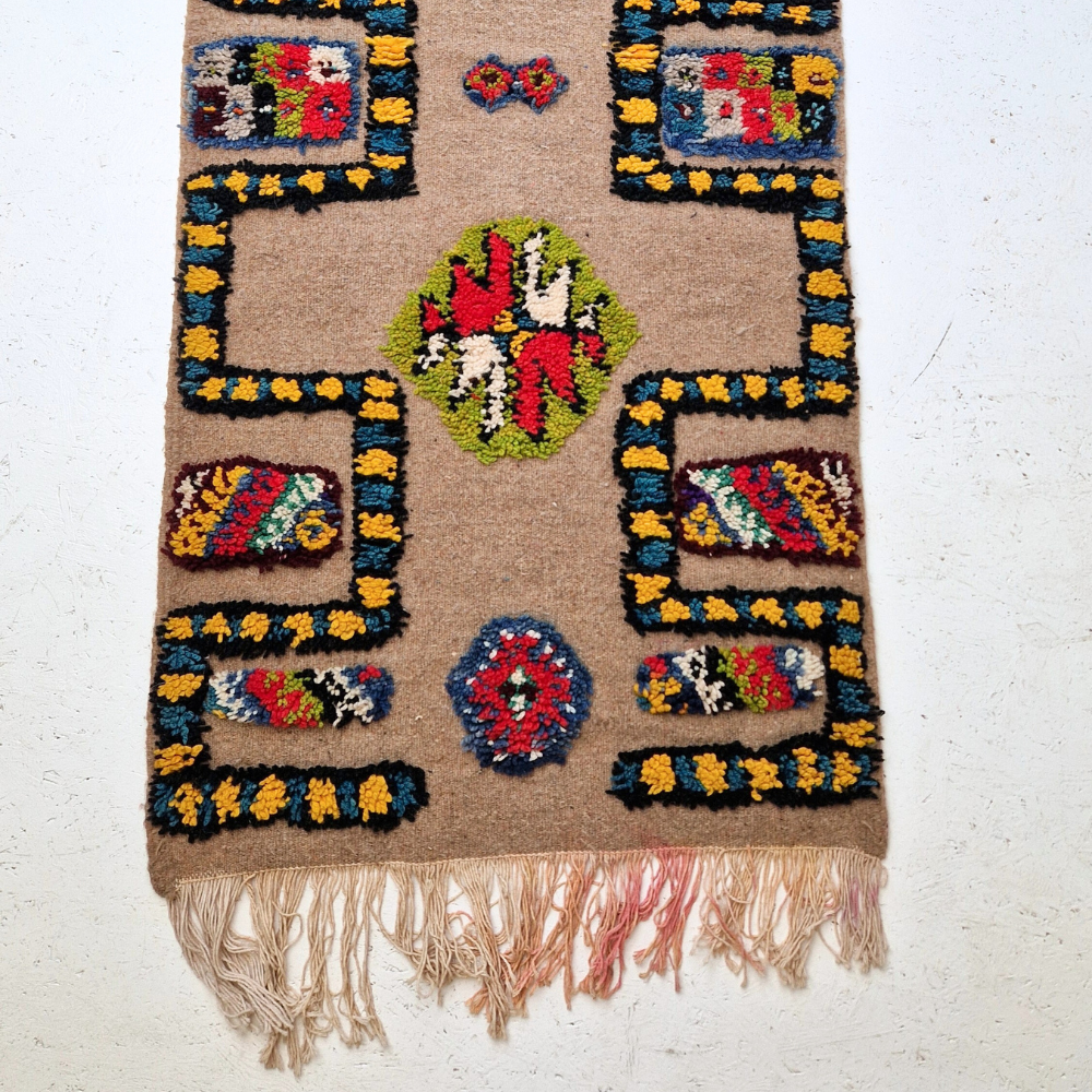 Bohemian Moroccan Azilal rug with bold geometric patterns in red, blue, white and multicolor wool, featuring abstract Berber tribal motifs and handwoven texture.