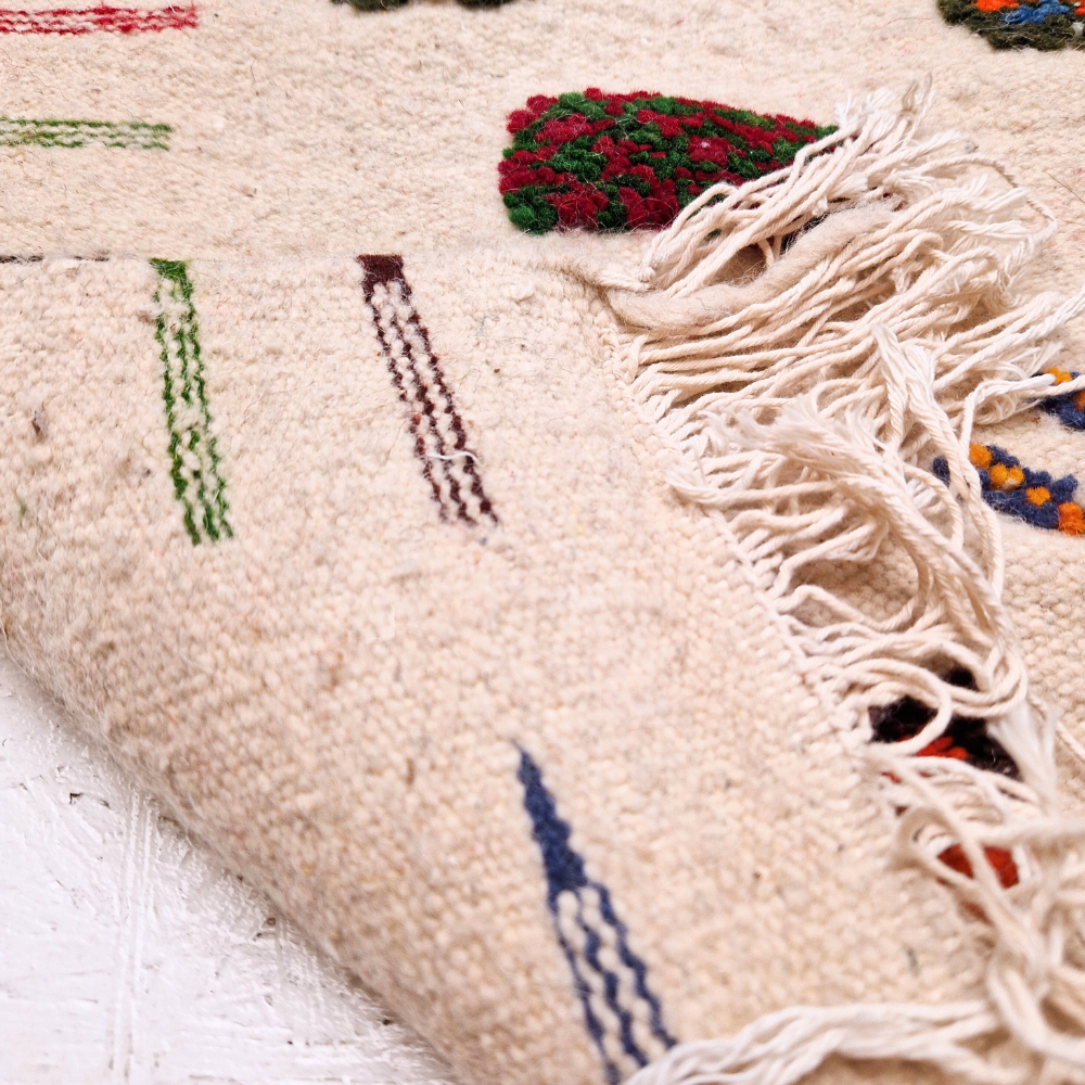 Bohemian Moroccan Azilal rug with bold geometric patterns in red, blue, white and multicolor wool, featuring abstract Berber tribal motifs and handwoven texture.