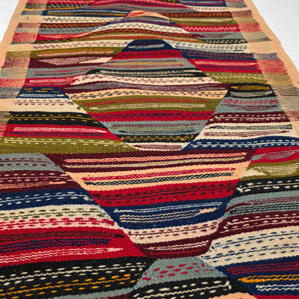Bohemian Moroccan Azilal rug with bold geometric patterns in red, orange, purple, and multicolor wool, featuring abstract Berber tribal motifs and handwoven texture.