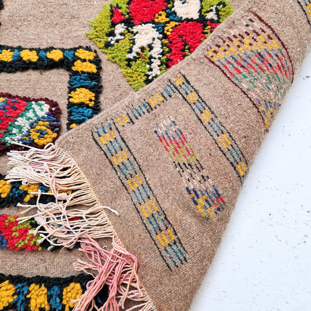 Bohemian Moroccan Azilal rug with bold geometric patterns in red, blue, white and multicolor wool, featuring abstract Berber tribal motifs and handwoven texture.