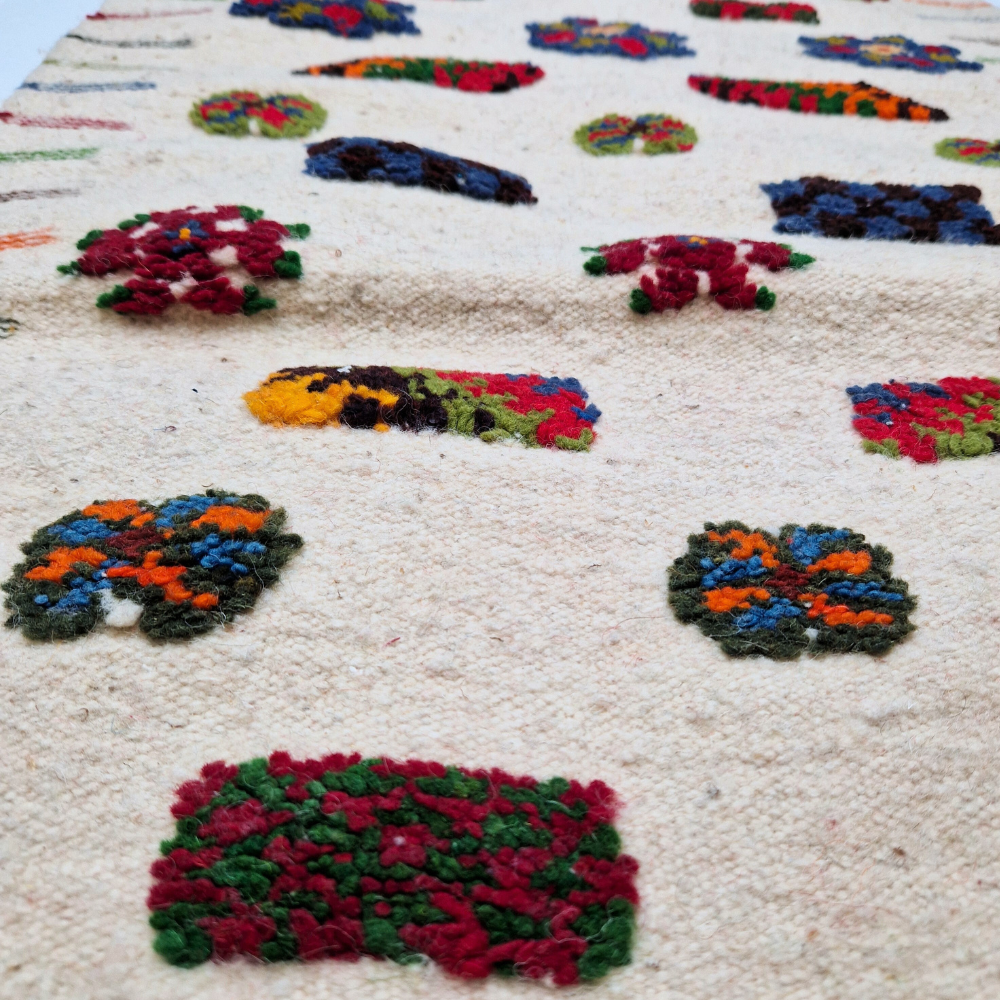 Bohemian Moroccan Azilal rug with bold geometric patterns in red, blue, white and multicolor wool, featuring abstract Berber tribal motifs and handwoven texture.