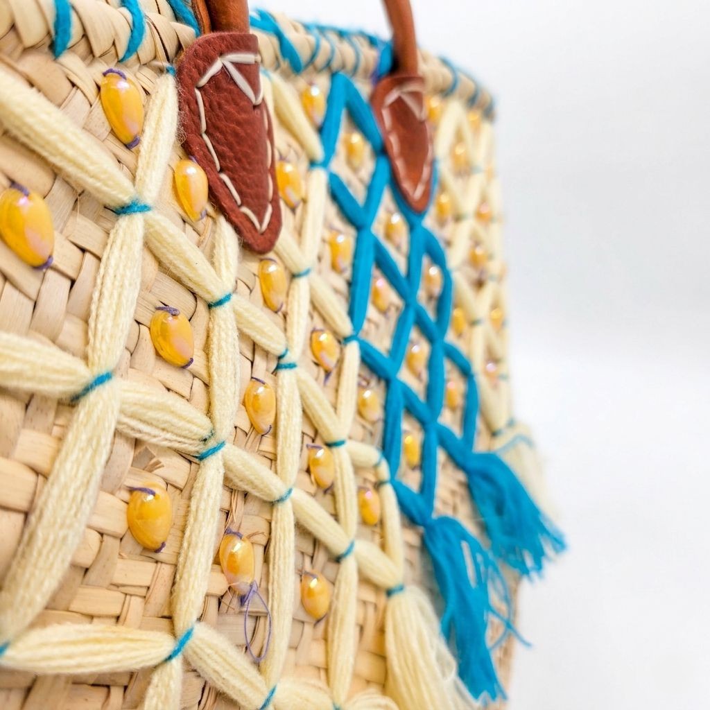 Close-up of amber crystal beads and teal straw lattice on handwoven Moroccan basket bag