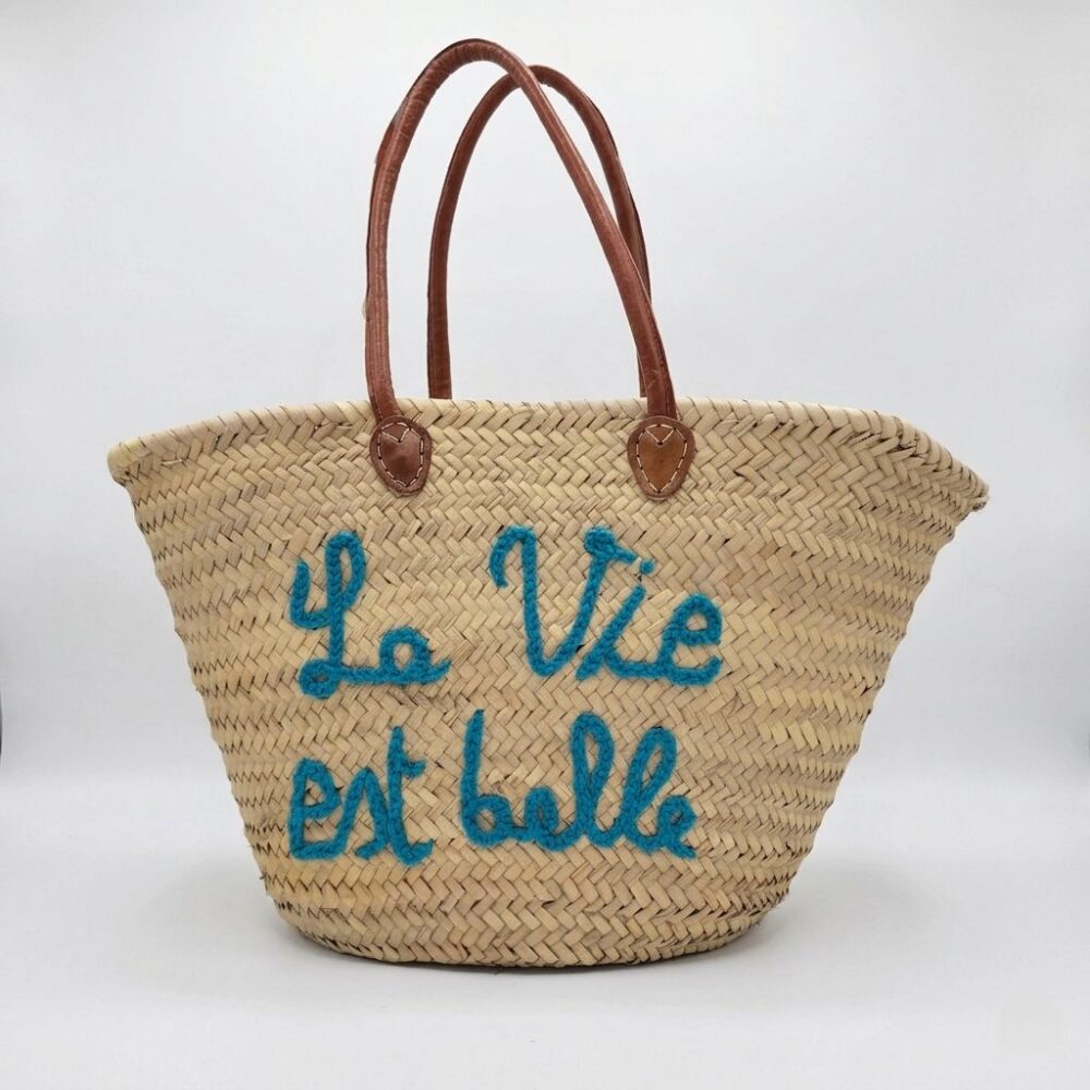 French quote basket bag with "La Vie est Belle" hand-stitched in teal thread and leather handles